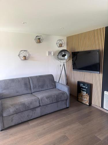 a living room with a couch and a flat screen tv at Chambre d'Hôtes Arla Goxoki in Amendeuix-Oneix