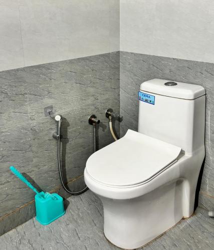 a bathroom with a white toilet in a stall at Sunrise View Farm-stay -Narkanda in Shimla