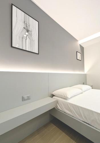 a bedroom with a bed and a picture on the wall at The Superhost - IL Lux in Crotone