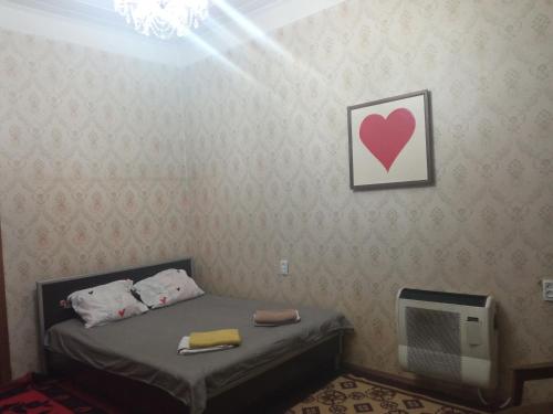 a room with a bed with a heart on the wall at room with a mountain view in Zugdidi