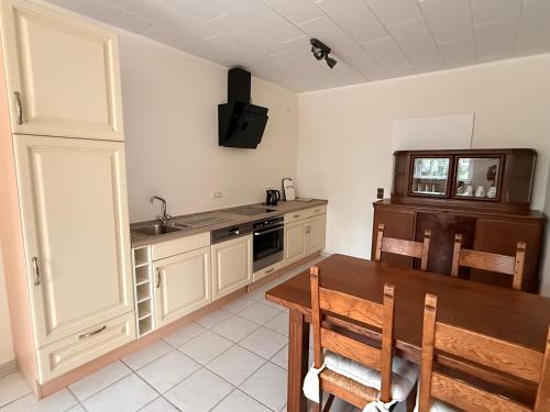 a kitchen with a wooden table and a sink at Haus an der Hase in Bramsche