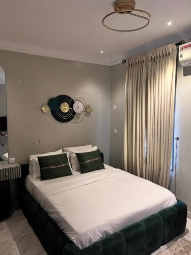 a bedroom with a large bed with a clock on the wall at Executive 2-Bedroom Apartment in Ikeja