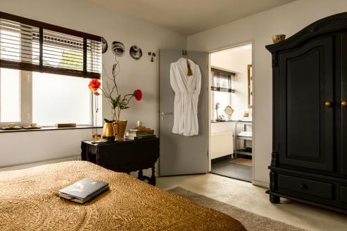a bedroom with a bed and a bathroom with a sink at B&B Habitat in Beverwijk