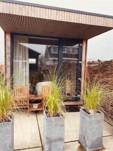 a patio with potted plants in metal containers at B&B Pardoen in Poortugaal