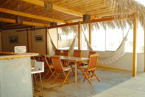 a dining room with a wooden table and chairs at El Hueco Villas in Lobitos