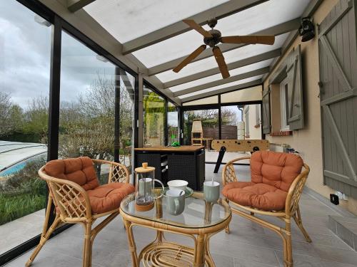 a patio with a table and chairs and a ceiling fan at La fleur des eaux de Beauval in Noyers-sur-Cher