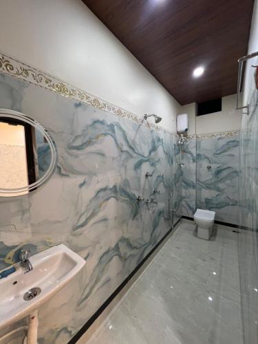 a bathroom with a sink and a shower and a toilet at Jalangi Empire in mayapur