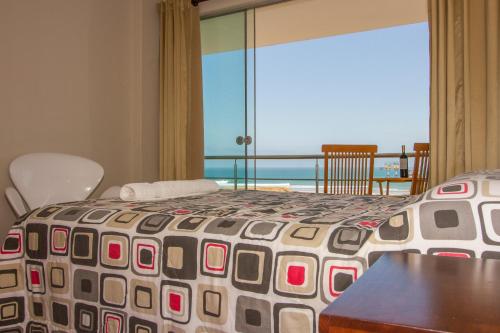 a bedroom with a bed with a view of the ocean at El Hueco Villas in Lobitos