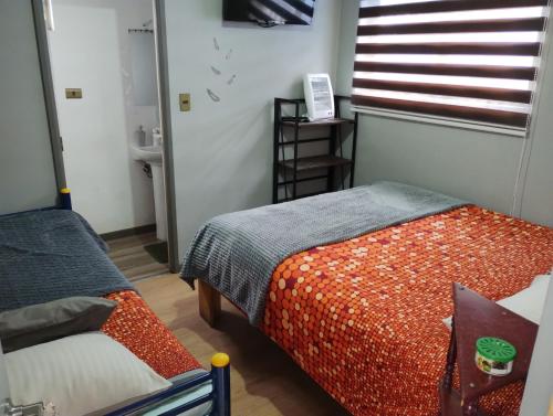 a small room with a bed and a window at EL ROBLE 2 CHILLaN in Chillán