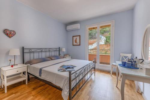 a bedroom with a bed and a desk and a window at Capo d'Arco - Quadrilocale Le Mimose in Capo D'Arco