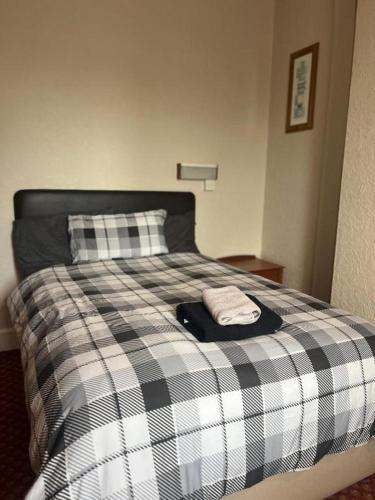 a bed with a black and white checkered blanket at Hylands Hotel Double Room with Shared Bathroom & Free Parking in Nottingham
