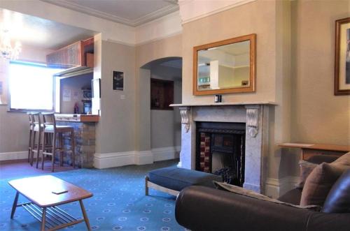 a living room with a couch and a fireplace at Hylands Hotel Double Room with Shared Bathroom & Free Parking in Nottingham