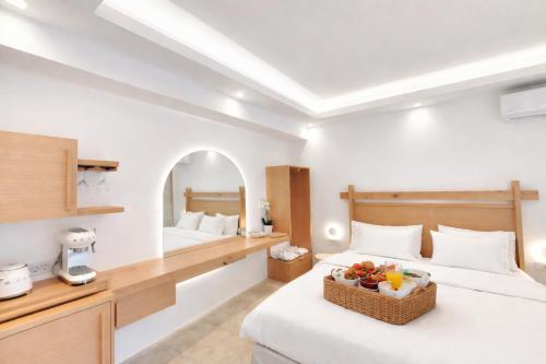a hotel room with two beds and a bowl of fruit on the bed at DelMar Suites Syros in Finikas