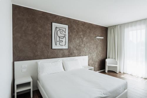 a bedroom with a white bed and a wall at Arca Guest House in San Trovaso