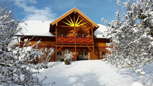 a log cabin in the snow with snow covered trees at Familien-Appartements Örglwirt's Gut in Mariapfarr