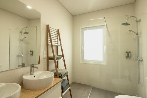 a bathroom with a sink and a shower and a ladder at Bay House in Ponta Delgada