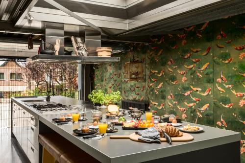 a kitchen with a table with food and orange juice at B&B Habitat in Beverwijk