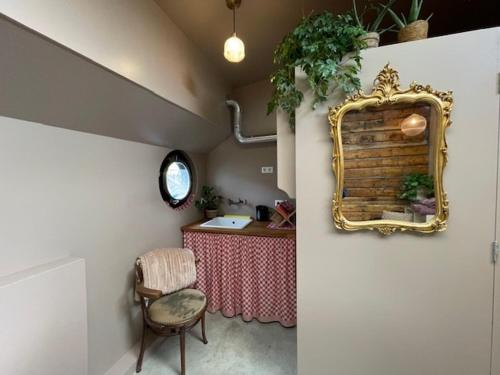 a room with a table and a mirror and a chair at Houseboat Tante Piet in Amsterdam