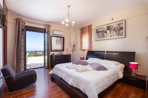 a bedroom with a bed and a chair and a window at Villa Rosemary - Luxury Nature Escape in Roussospítion