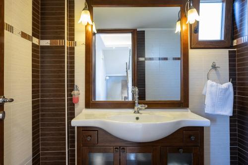 a bathroom with a sink and a mirror at Villa Rosemary - Luxury Nature Escape in Roussospítion