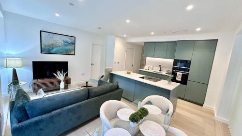 a living room with a blue couch and a kitchen at Sunshine Place Brent Cross in London