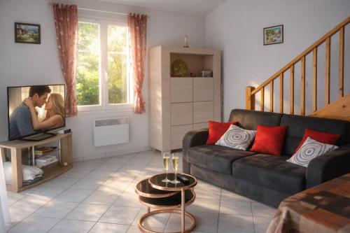 a living room with a couch and a couple kissing at Appartement calme grande terrasse 150 m de la plage in Meschers-sur-Gironde