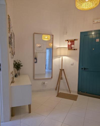 a bathroom with a mirror and a sink and a door at Albur Beach House in Alvor