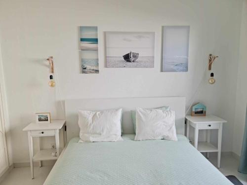 a bedroom with a bed with two tables and two pictures at Albur Beach House in Alvor