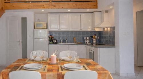 a kitchen with a wooden table and white cabinets at Appartement calme grande terrasse 150 m de la plage in Meschers-sur-Gironde