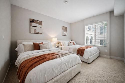 two beds in a bedroom with a window at Promo Casa Miel Heart of Westwood Luxury Condo in Los Angeles