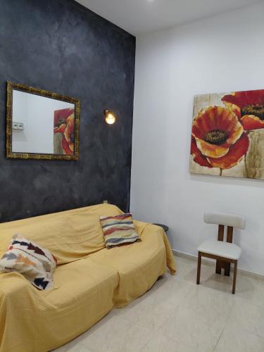 a bedroom with a yellow bed and a mirror at Charming Ground-floor Maisonette in Birgu
