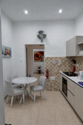 a kitchen with a table and chairs in a room at Charming Ground-floor Maisonette in Birgu