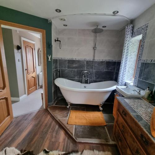 a large bathroom with a tub and a sink at Calderbrook House in Hebden Bridge