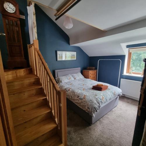 a bedroom with a bed next to a staircase at Calderbrook House in Hebden Bridge