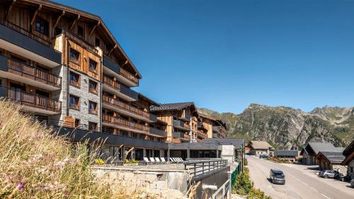 a building on the side of a road next to a mountain at MGM Hôtels & Résidences - Résidence Alpen Lodge in La Rosière