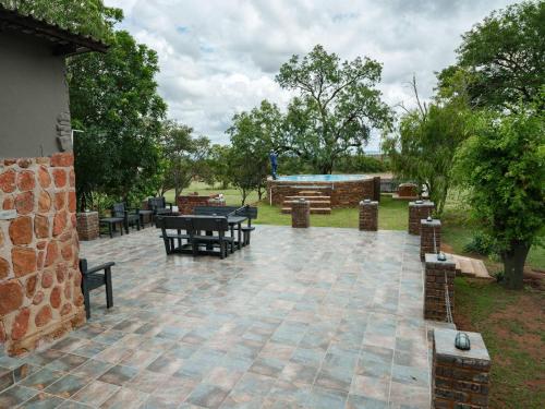 a patio with picnic tables and benches in a park at Impala Game Ranch in Dinokeng Game Reserve