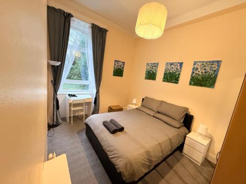 a bedroom with a bed and a window at Paisley Pad Glasgow Gateway second floor flat in Paisley