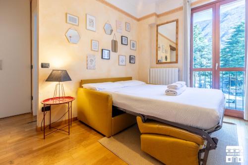 a bedroom with a bed and a yellow chair at AL LAGO by Design Studio in Bellano