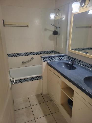 a bathroom with a sink and a tub and a mirror at Heliotel Marine plages piscines tennis terrasse jardin in Saint-Laurent-du-Var