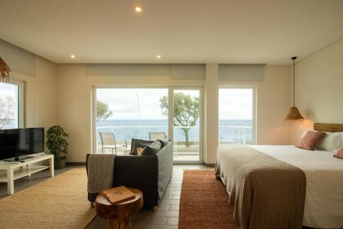 a bedroom with a bed and a view of the ocean at Bay House in Ponta Delgada