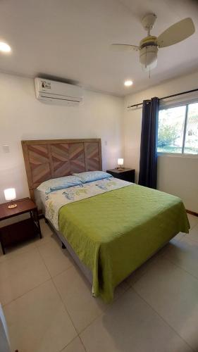 a bedroom with a green bed and a window at Villas Pura Vida - Marañón in Puntarenas