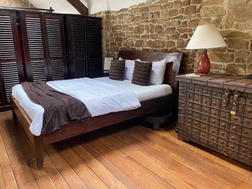 a bedroom with a bed and a table with a lamp at Grange de la Rochette - 1 à 6p in Jamoigne