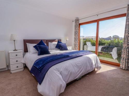 a bedroom with a large bed and a large window at Star Carr Lakes in Great Driffield