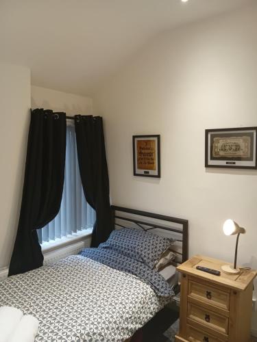 a bedroom with a bed and a table with a lamp at Dale combe in Middleton