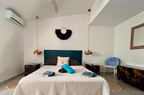a bedroom with a bed with two blue pillows on it at Sole e Mare NBBC sur la plage de Baie Nettlé in Baie Nettle