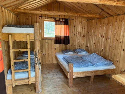 a bedroom with two bunk beds in a wooden cabin at Ülesaare kämping in Kelnase