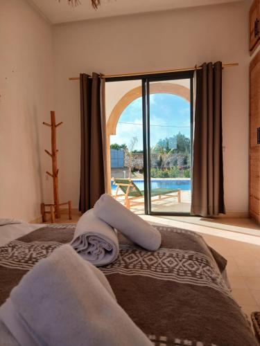 a bedroom with two beds and a large window at Chambres Maison d'hôtes MaisonBlanche in Essaouira