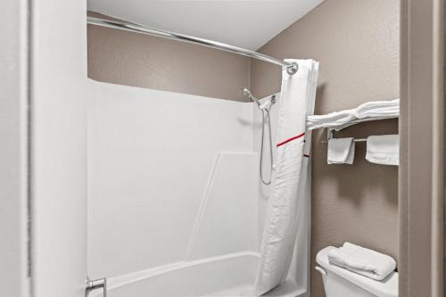a bathroom with a shower and a toilet with towels at Red Roof Inn Ardmore in Ardmore