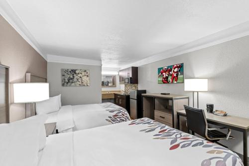 a hotel room with two beds and a desk at Red Roof Inn Ardmore in Ardmore