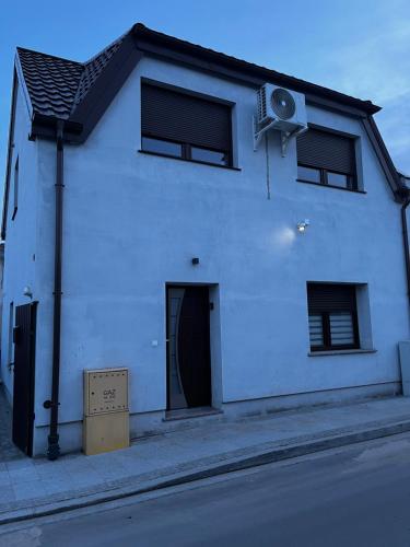 a white building with a speaker on the side of it at Powidz Cozy Apartament in Powidz